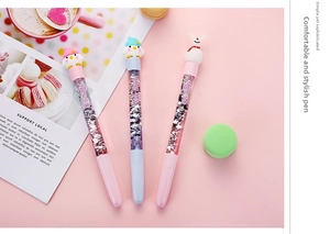 Close-up of cute cartoon gel pens with glitter quicksand and penguin character toppers