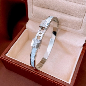 Macro detail of silver cuff bracelet with double T structure and light blue mother of pearl