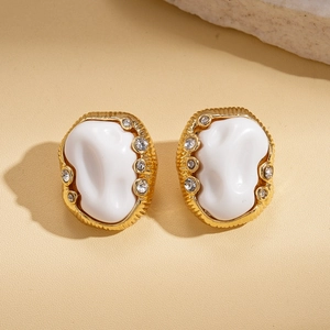 Detailed shot of retro oval earrings with textured gold plating and resin inlay