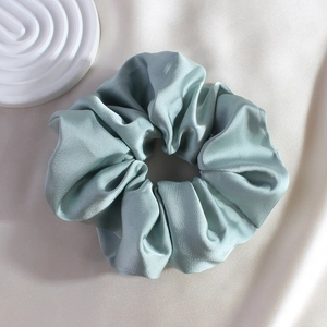 Close-up of light blue silk satin scrunchie showing glossy texture on soft fabric
