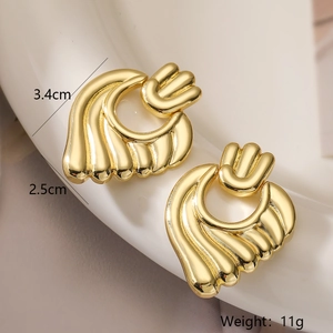 Detailed view of gold heart earrings with sizes 3.4cm by 2.5cm and textured finish