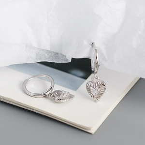 Close-up of silver heart drop earrings with radiant texture and centered zircon stones
