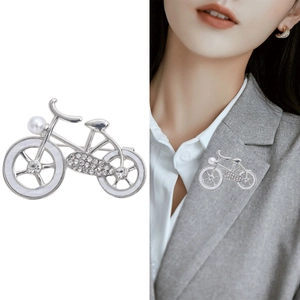 Silver bicycle brooch with pearls and rhinestones shown on model and white background