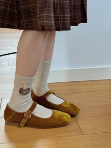 Close-up of beige cotton socks featuring a brown plush cartoon bear patch detail