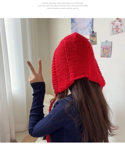 Détail du bonnet rouge à grosse maille avec protège-oreilles et texture douce