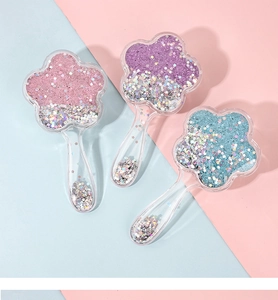 Detail of flower shaped hairbrushes with colorful sparkling sequins and star glitters