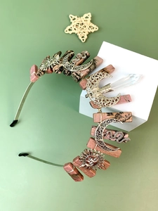 Detail of pink crystal crown headband with golden sun and moon metal accessories