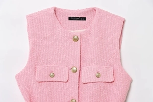 Detail of pink tweed vest with gold buttons and textured weave fabric for women