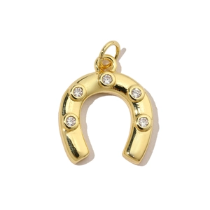 Close-up of a gold U-shaped horseshoe pendant inlaid with five sparkling cubic zirconia gems