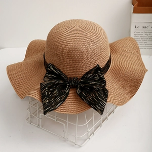 Summer wide brim straw sun hat with black bow and wavy edge for beach vacation