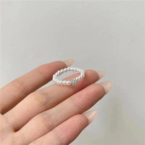 Detailed close-up of a French retro pearl ring with a sparkling pavé zircon ball on a finger