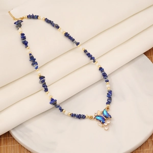Macro detail of natural blue crushed stone necklace with a crystal butterfly pendant
