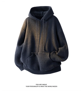 Detail of heavyweight knit hoodie featuring vintage washed effect and kangaroo pocket