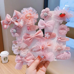 Pink girls hair clip set featuring mesh bows and flower motifs on a white display card