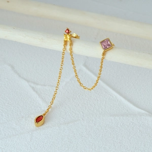 Detail view of S925 sterling silver long tassel earrings with colorful zircons on a wooden stand