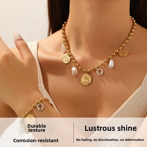 Detail of baroque pearl and religious portrait medals on gold beaded necklace set