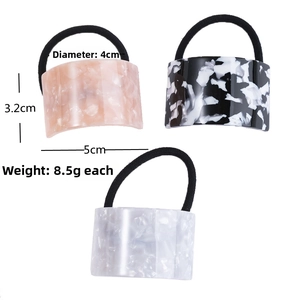 Close-up of marble pattern acetate hair tie with geometric semi-circle buckle detail