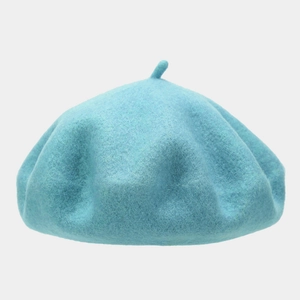 Detail of light blue wool beret featuring a classic top stem and soft felt texture
