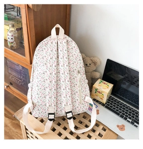 Detail of floral canvas backpack featuring pink flower prints and side water bottle pocket