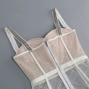 Detail of sheer mesh dress featuring sequin patterns and rhinestone shoulder straps