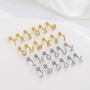 Close-up of A-Z alphabet ear studs in gold and silver with micro-pave zircons