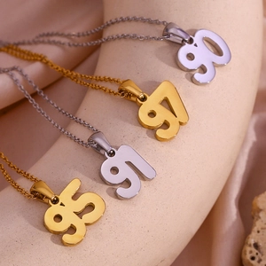 Detail of 18K gold and silver necklaces featuring 90, 91, 95, 97 year pendant numbers