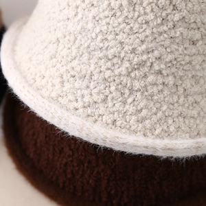 Close-up of thick plush faux fur texture on cream and brown winter bucket hats