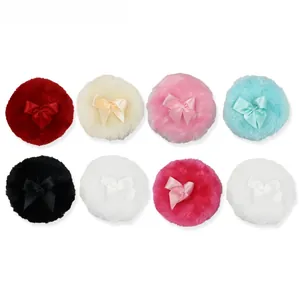 Set of eight plush powder puffs with satin bows in various vibrant colors on white background