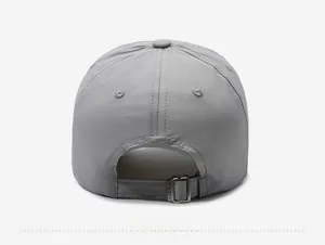 Detail view of the gray baseball cap featuring an adjustable metal buckle strap at the back