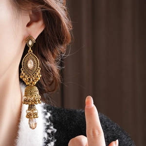 Détails macro des boucles d'oreilles Jhumka vintage avec cristaux ambrés et glands en bronze