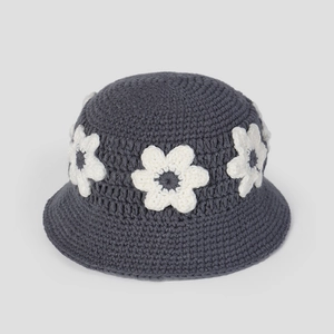 Détail d'un chapeau cloche au crochet gris foncé avec de délicates fleurs tricotées blanches