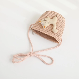 Detail view of straw crossbody bag featuring a cute 3D cartoon cat doll for children