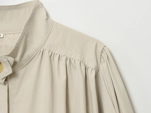 Nahaufnahme von Faltenkragen und Nähten einer beigefarbenen Freizeitjacke