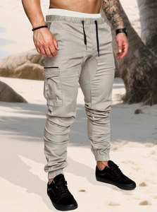 Close-up of beige cargo pants featuring drawstring elastic waist and flap utility pockets