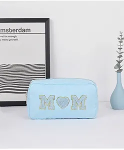 Blauwe chenille toilettas met glinsterende M-hart-M patches en een ritssluiting