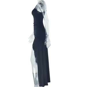 Detail eines hohen Seitenschlitzes und Taillenfalten an einem schwarzen Maxikleid