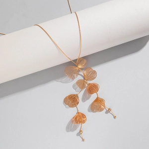 Détail du collier à pampilles en feuille de ginkgo doré avec pétales en métal tissé