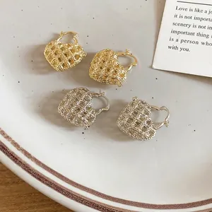 French vintage hollow heart hoop earrings in gold and silver set on a ceramic plate