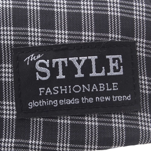 Macro shot of black and white plaid newsboy hat fabric with embroidered fashion label