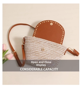 Detail view of woven straw crossbody bag showing internal capacity and magnetic closure