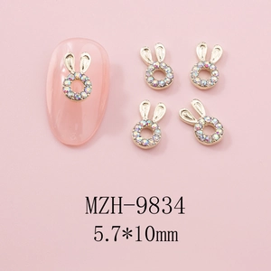 Makroansicht von süßem 3D Hasen-Nagelschmuck mit glitzernden Strasssteinen und Goldrahmen