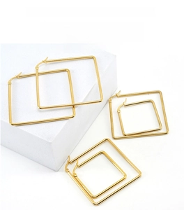 Three sizes of polished golden square hoop earrings displayed on white geometric stands