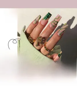 Dettaglio di unghie finte opache verdi con texture coccodrillo, bordo oro e motivo serpente