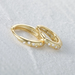Detailed close-up showing the S925 silver stamp and zircon stones on gold hoop earrings