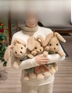 Tre peluche a forma di coniglio con abiti a quadri colorati in un ambiente accogliente