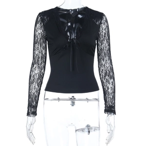 Close-up of black V-neck lace patchwork top with long sleeves and delicate bow detail