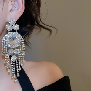 Close-up of model wearing silver tassel earrings with sparkling rhinestones and crystals