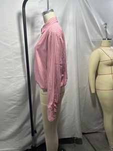 Dettaglio camicia a righe rosa con maniche lunghe, orlo elastico e polsini con bottoni