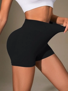 Detail showing the high elasticity and ribbed texture of black high-waisted yoga shorts