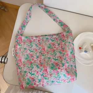 Detailed view of floral cotton tote bag with pink flower pattern and simple wish label